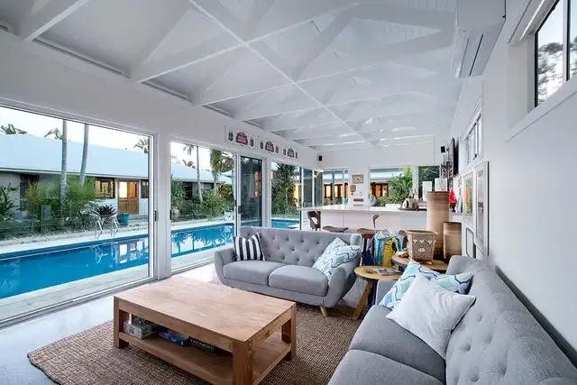 A Living Room With a Couch  and Sliding Glass Doors — Michael Duncan Constructions Pty Ltd in Robina, QLD