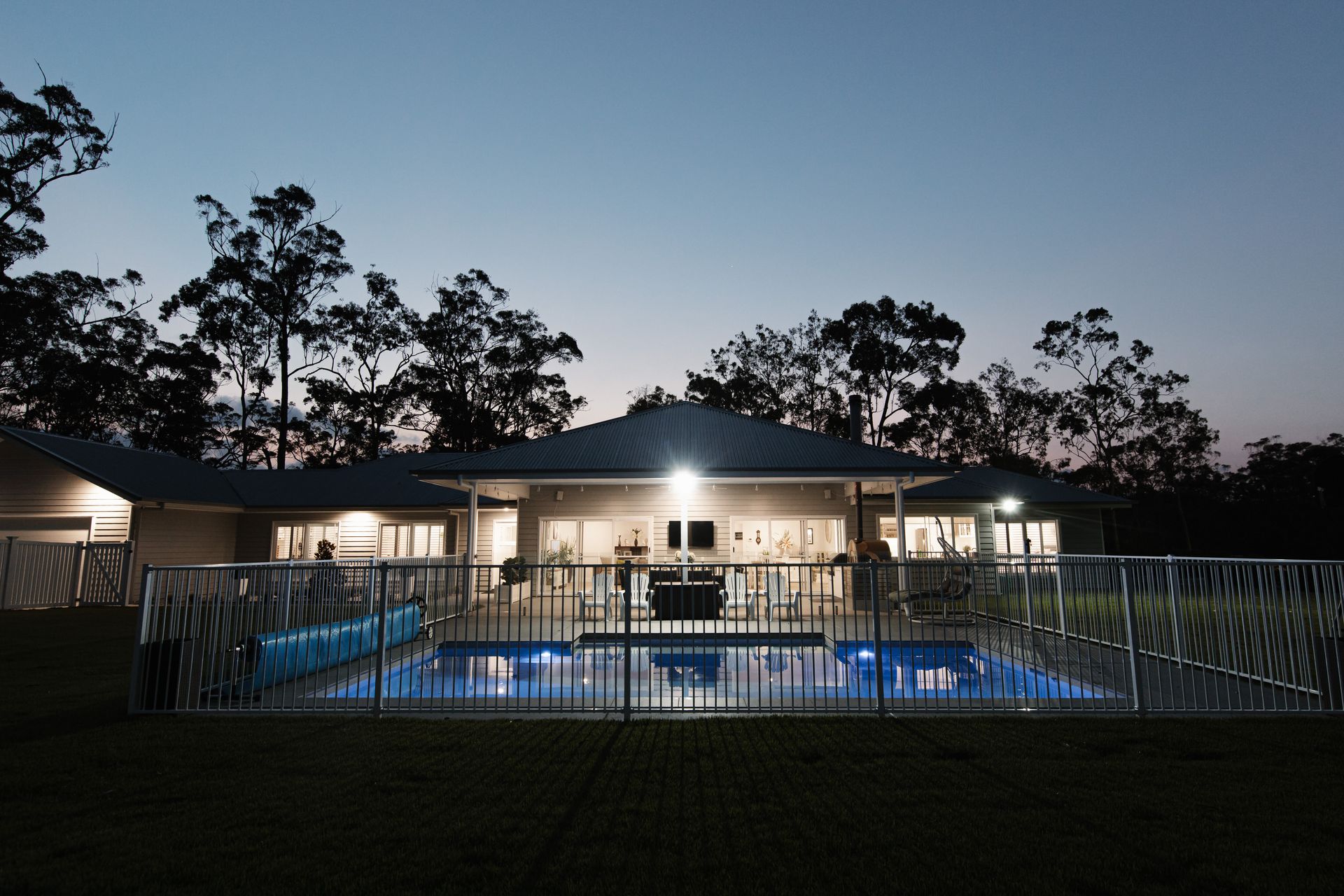 A Kitchen With a Grill and Stools Next to a Pool — Michael Duncan Constructions Pty Ltd in Robina, QLD