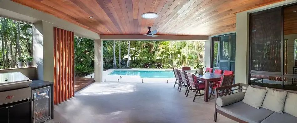 A Large Patio With a Swimming Pool and a Table and Chairs — Michael Duncan Constructions Pty Ltd in Mermaid Beach, QLD