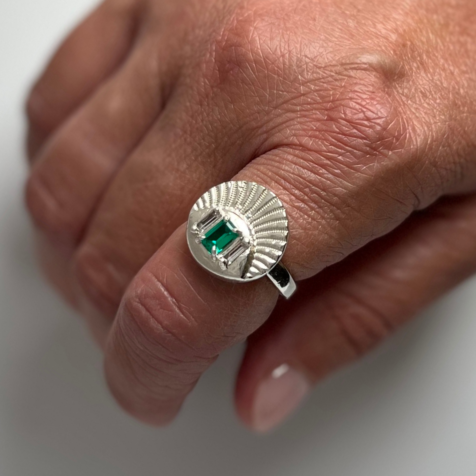 Silver ring with emerald stone on a hand. Wild Sunflower Silver Handmade Jewelry