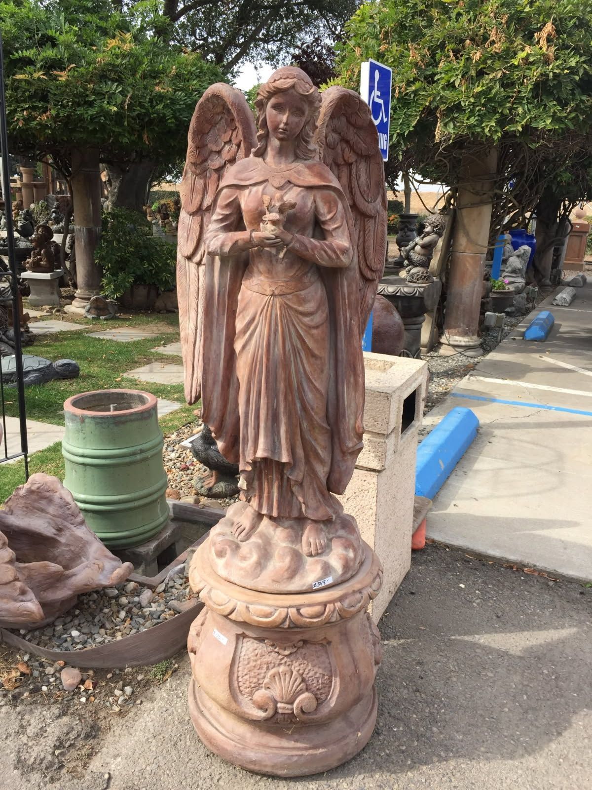 Stone angel statue on a pedestal in an outdoor park setting
