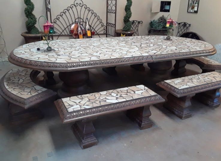 Large mosaic tile dining table with matching benches in a living room