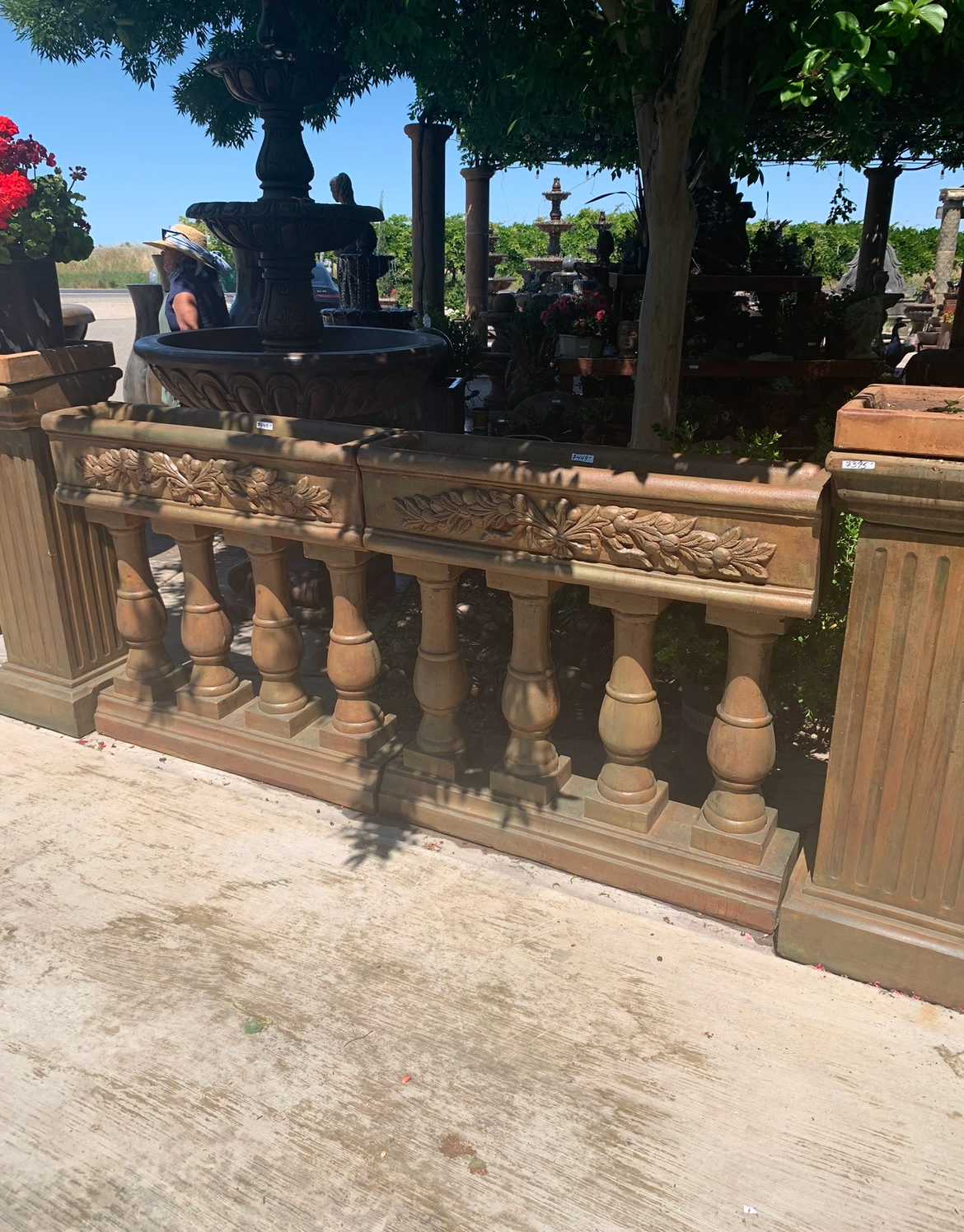 Stone balustrade in a sunny park with trees and a fountain in the background