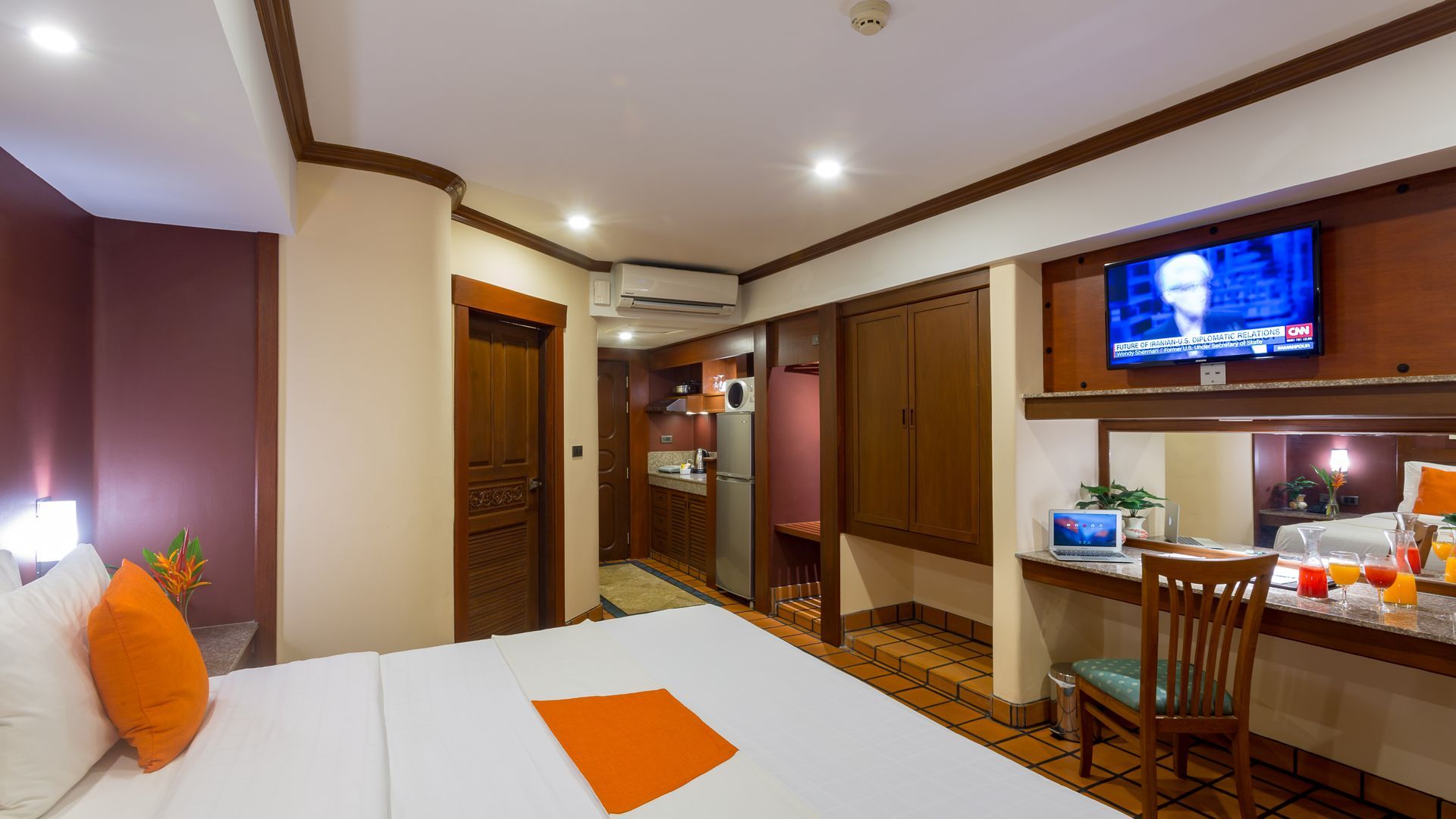 A hotel room with a large bed , desk and television.