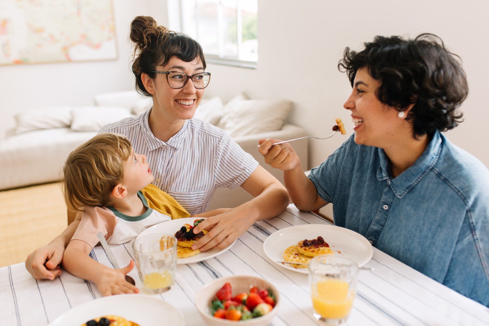 Two moms eating breakfast with their daughter