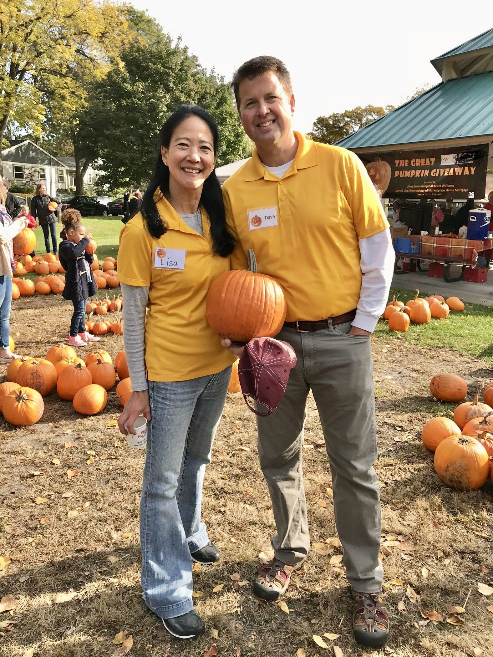 A man and a woman are posing for a picture at a pumpkin patch