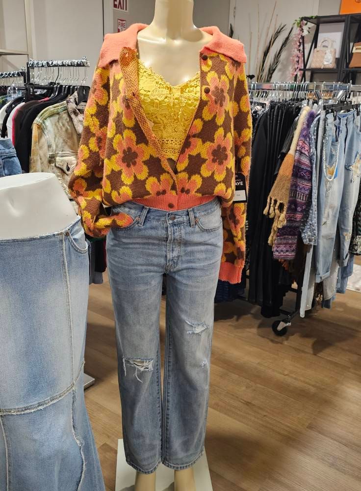 Mannequin in boutique wearing floral blouse and yellow top with light blue jeans