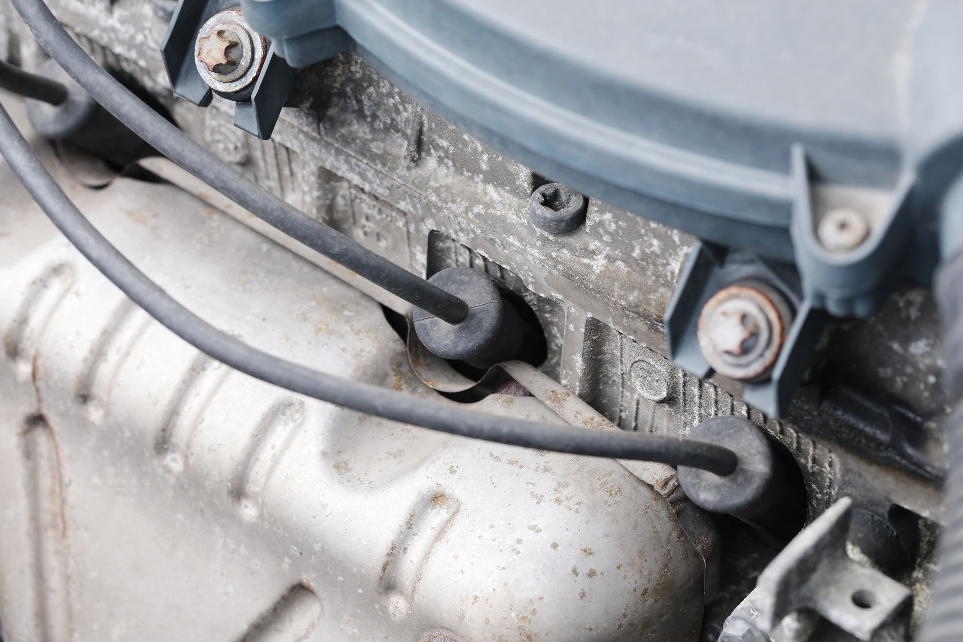 Close-up of engine components showing spark plugs and ignition wires attached to a cylinder head. Close-up of engine components showing spark plugs and ignition wires attached to a cylinder head.
