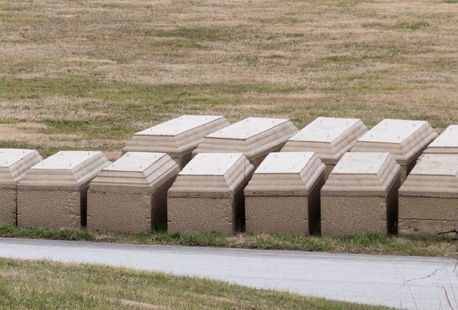 A row of burial vaults next to a pathway.