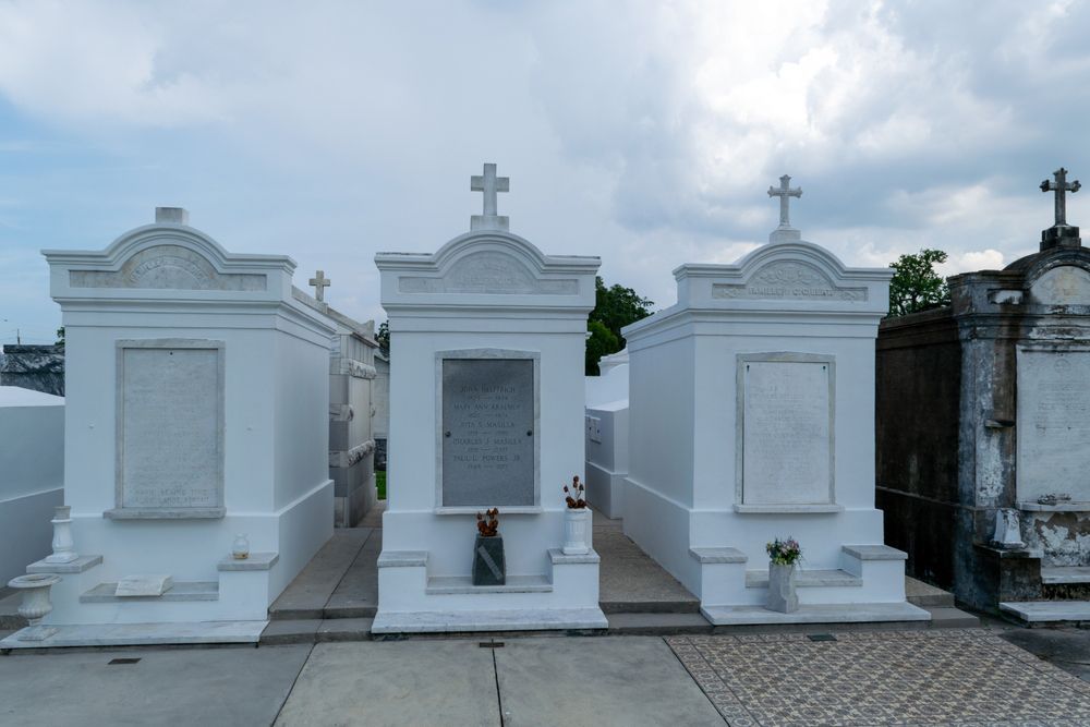 A cemetery with white graves and a cross on top