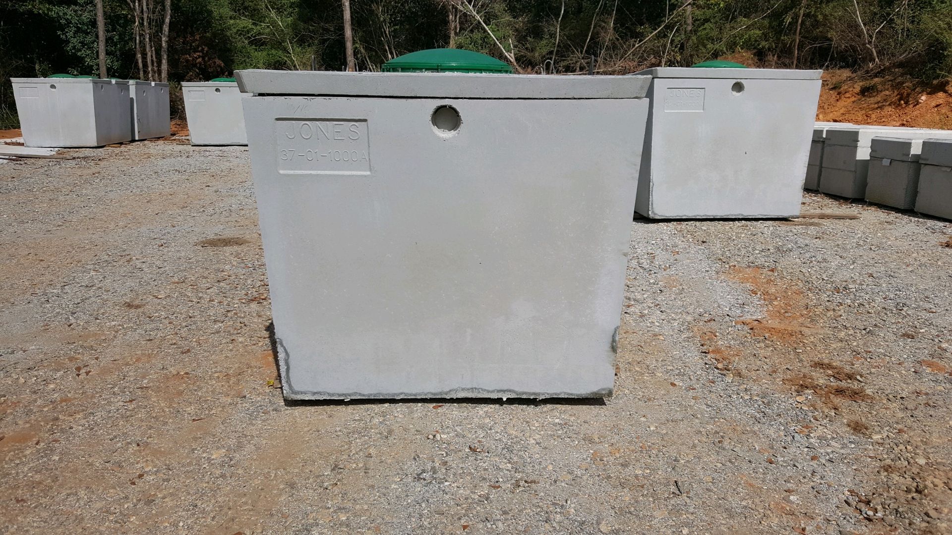 A large concrete tank is sitting on top of a flatbed truck.