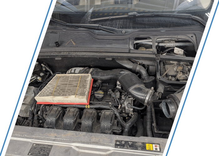 Engine bay with cooling components exposed during automotive air conditioning service.