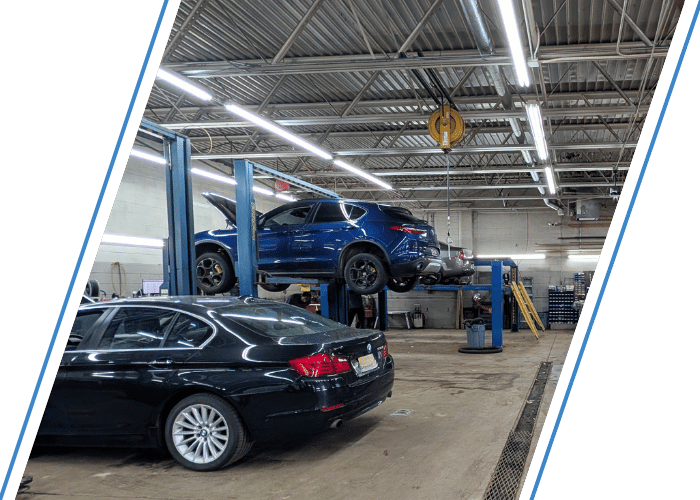 Luxury vehicles inside a professional auto repair shop with multiple cars on service lifts.