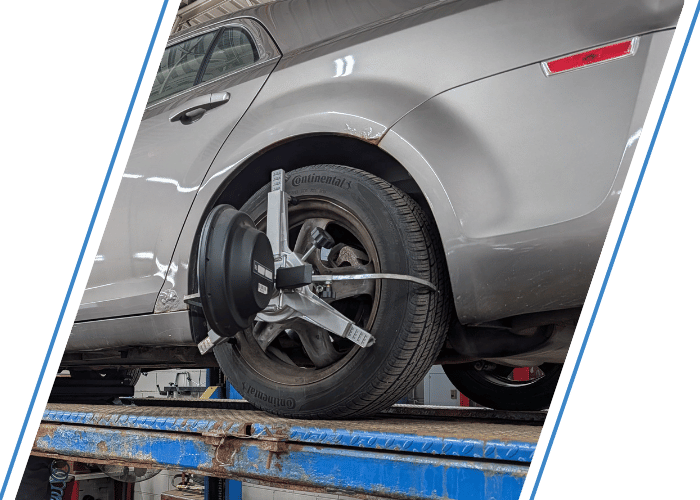 Vehicle on an alignment rack with a wheel alignment sensor attached during a precision alignment service.