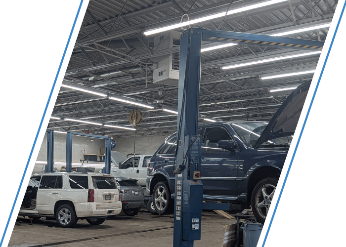 Luxury SUV undergoing maintenance on a vehicle lift inside a modern repair facility.