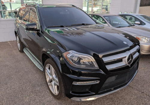 Black Mercedes-Benz GL-Class SUV parked outside an automotive service center