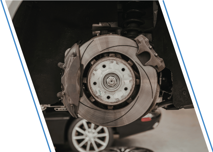 Close-up of a vehicle brake rotor and caliper with the wheel removed.