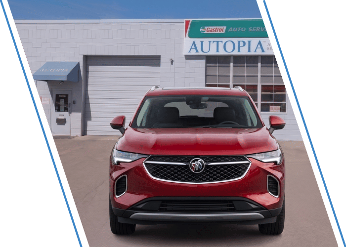 Front view of a red Buick SUV parked outside an auto repair shop.