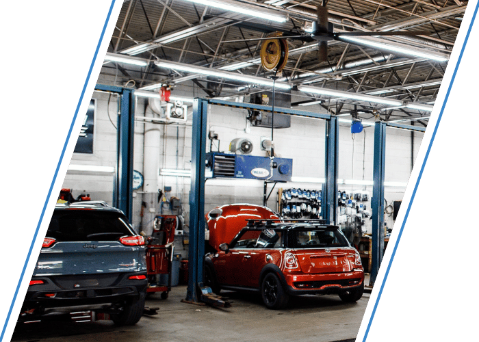 Sedan and SUV receiving maintenance inside a full service repair facility.
