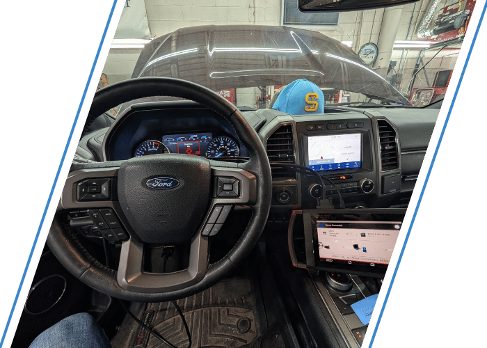 Interior of a Ford truck during electrical diagnostics with advanced diagnostic equipment connected.
