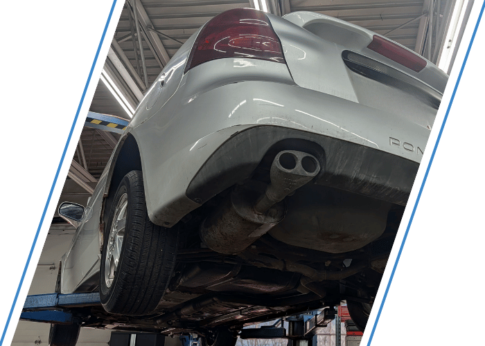 Rear underside of a Pontiac sedan on a lift highlighting the exhaust system and muffler.