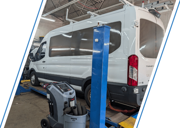 Multiple fleet vehicles inside a professional auto repair shop undergoing maintenance and service.