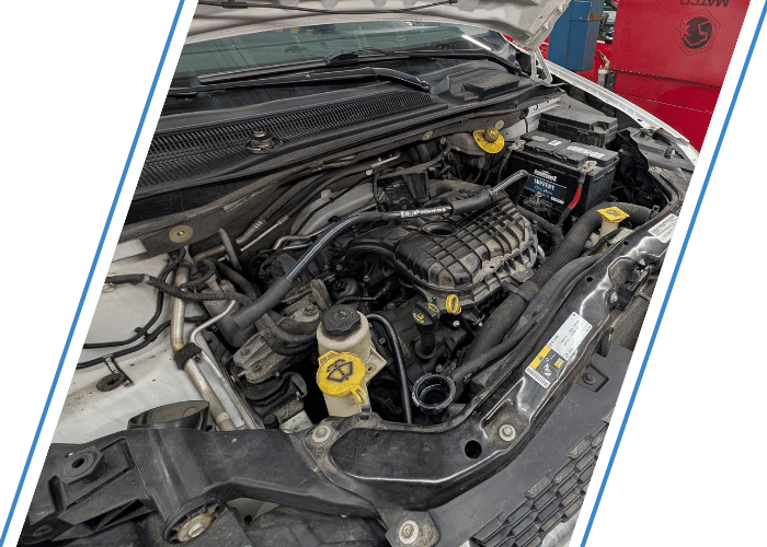 Engine bay with hood open during a fluid level inspection and top-off service.