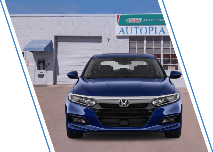 Front view of a blue Honda sedan parked outside an auto repair shop.
