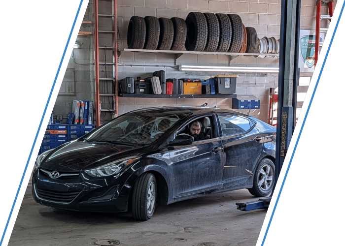 Black Hyundai Elantra inside a repair bay ready for inspection and service.