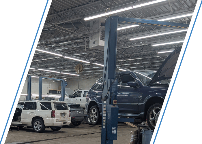 Luxury SUV undergoing maintenance on a vehicle lift inside a modern repair facility.