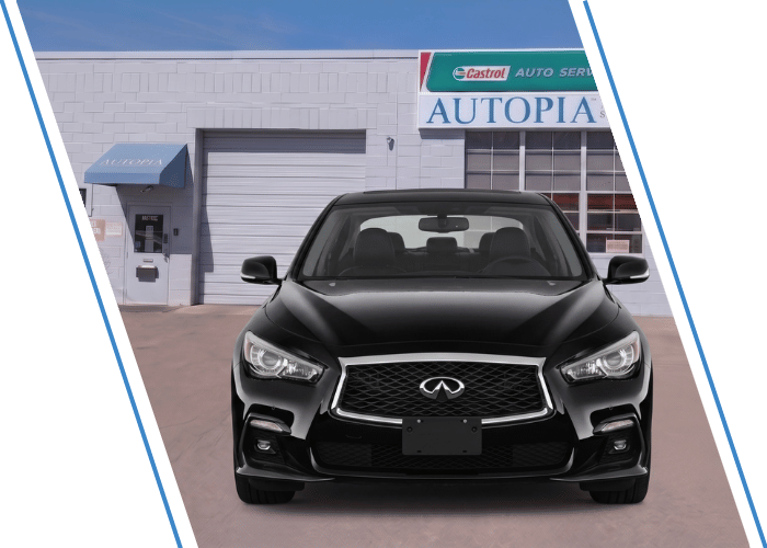 Front view of a black Infiniti sedan parked outside an auto repair shop.