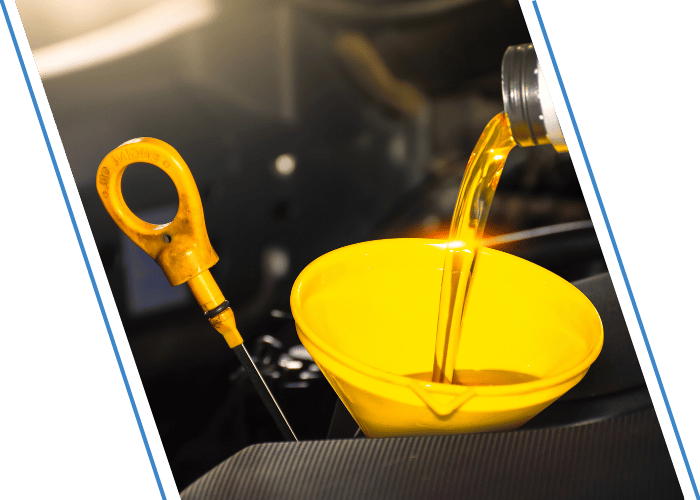 Fresh engine oil being poured into a vehicle through a funnel.