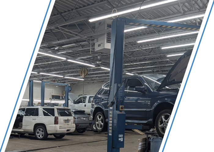 Luxury SUV undergoing maintenance on a vehicle lift inside a modern repair facility.
