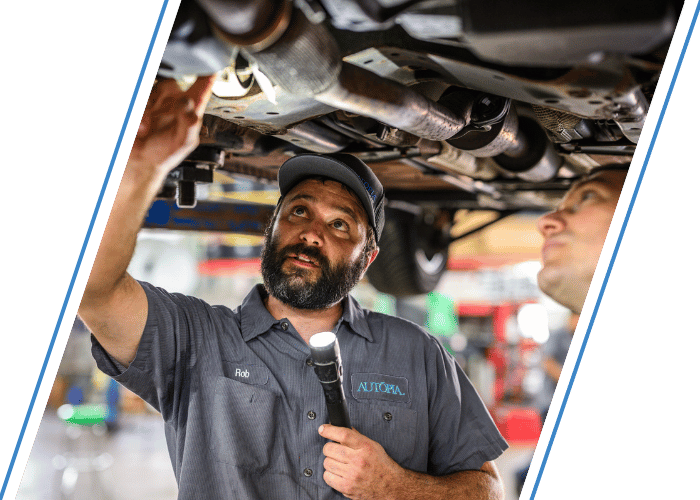 Two technicians inspecting a vehicle together before a potential purchase.