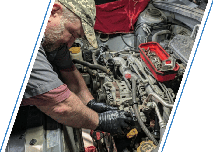 Technician replacing engine timing components during timing belt service.