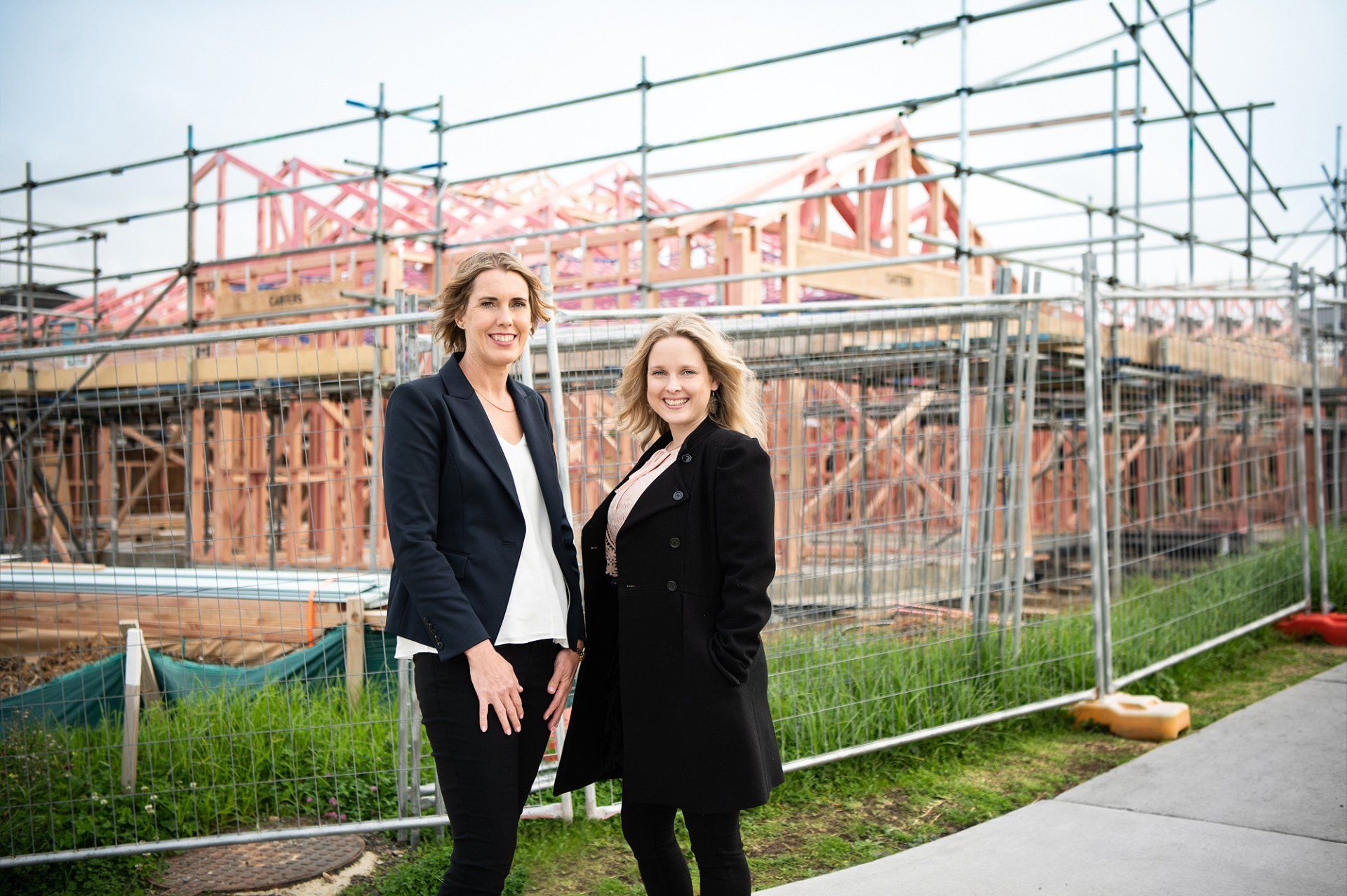 Vanessa and Lana standing in front of a scaffolded building under construction
