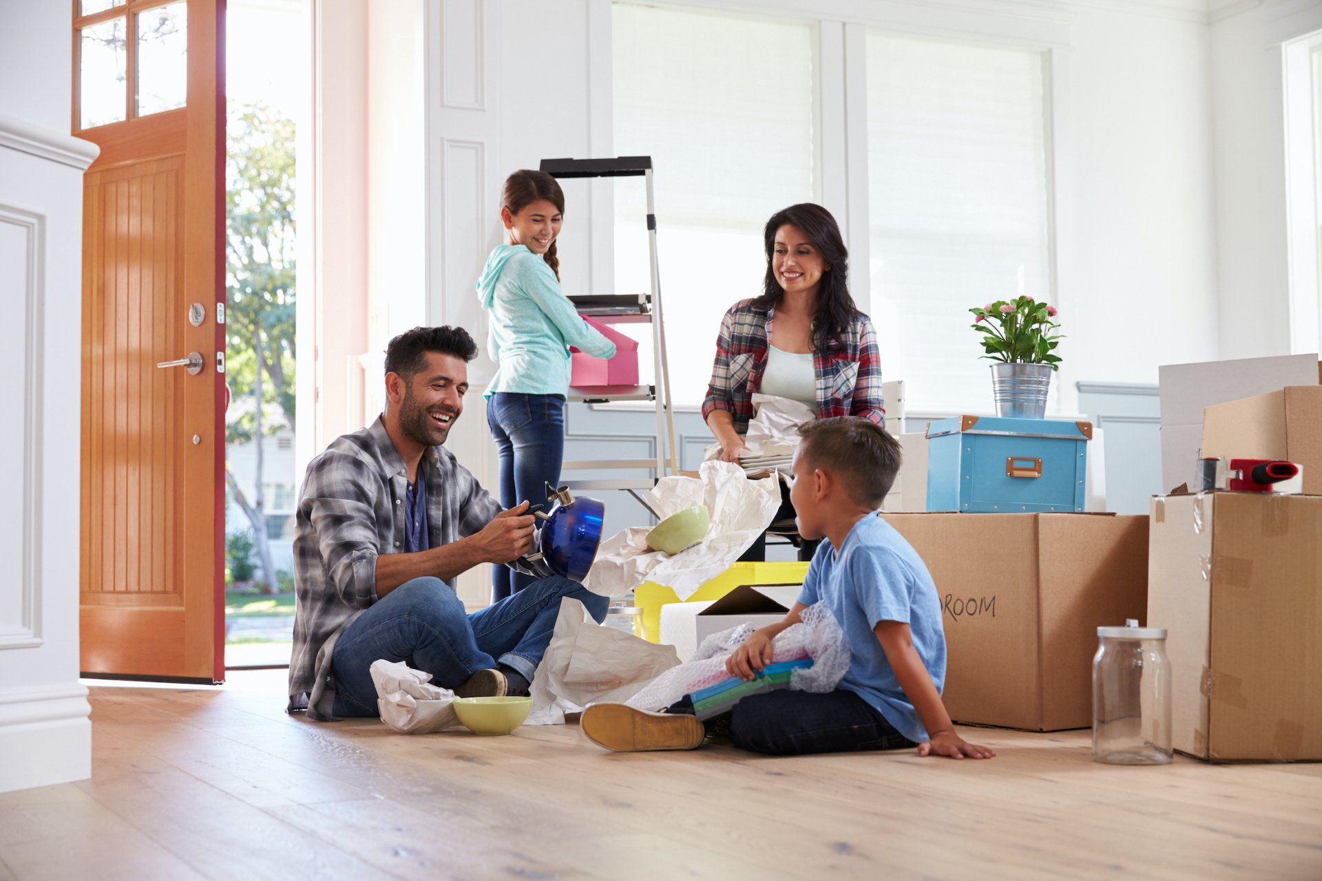 Family unpacking boxes in a bright living room during a move