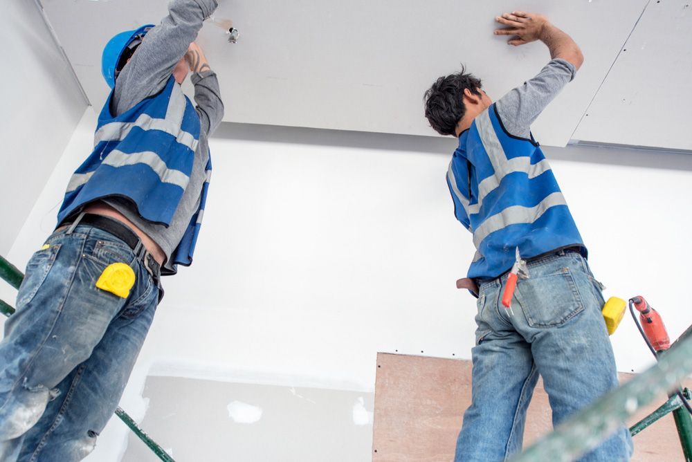 Two Construction Workers Are Working on The Ceiling of A Building — Hager Surveying In Currumbin, QLD