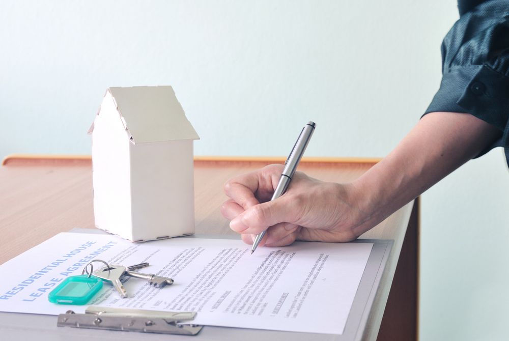 A Person Is Writing on A Piece of Paper with A Pen — Hager Surveying In Currumbin, QLD