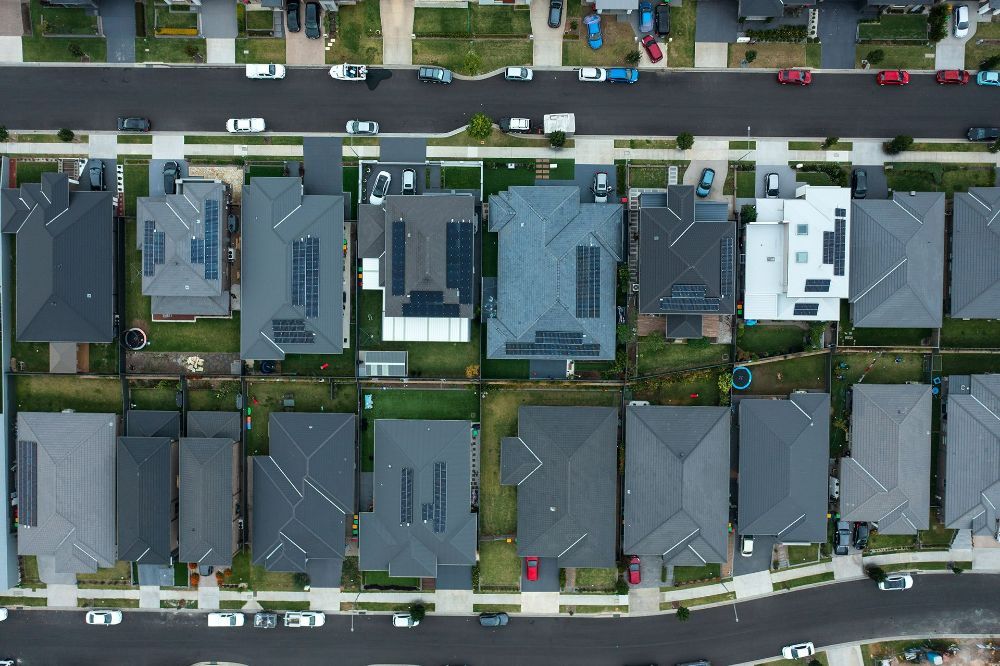 An Aerial View of A Residential Neighborhood with Lots of Houses and Cars — Hager Surveying In Banora Point, NSW