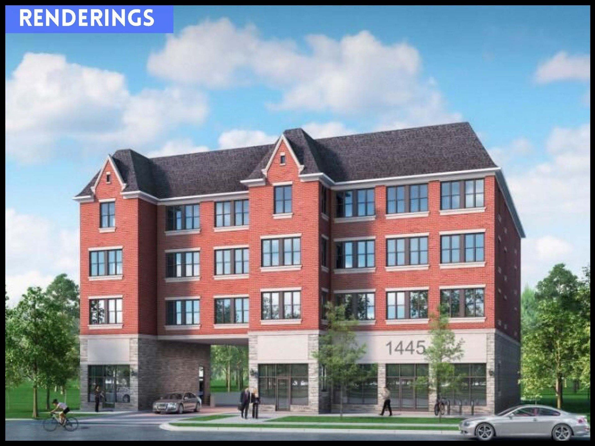 A four-story brick building with a stone-clad ground floor, a central arched drive-through, and a pitched roof.