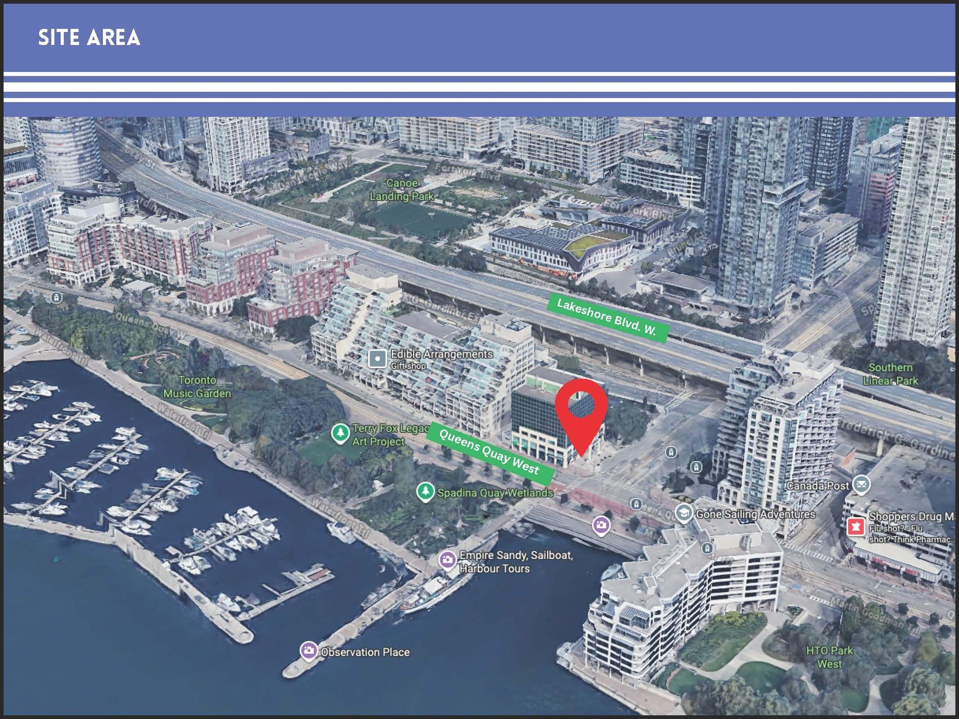 An aerial view of a waterfront urban neighborhood with a red map pin marking a specific site area.