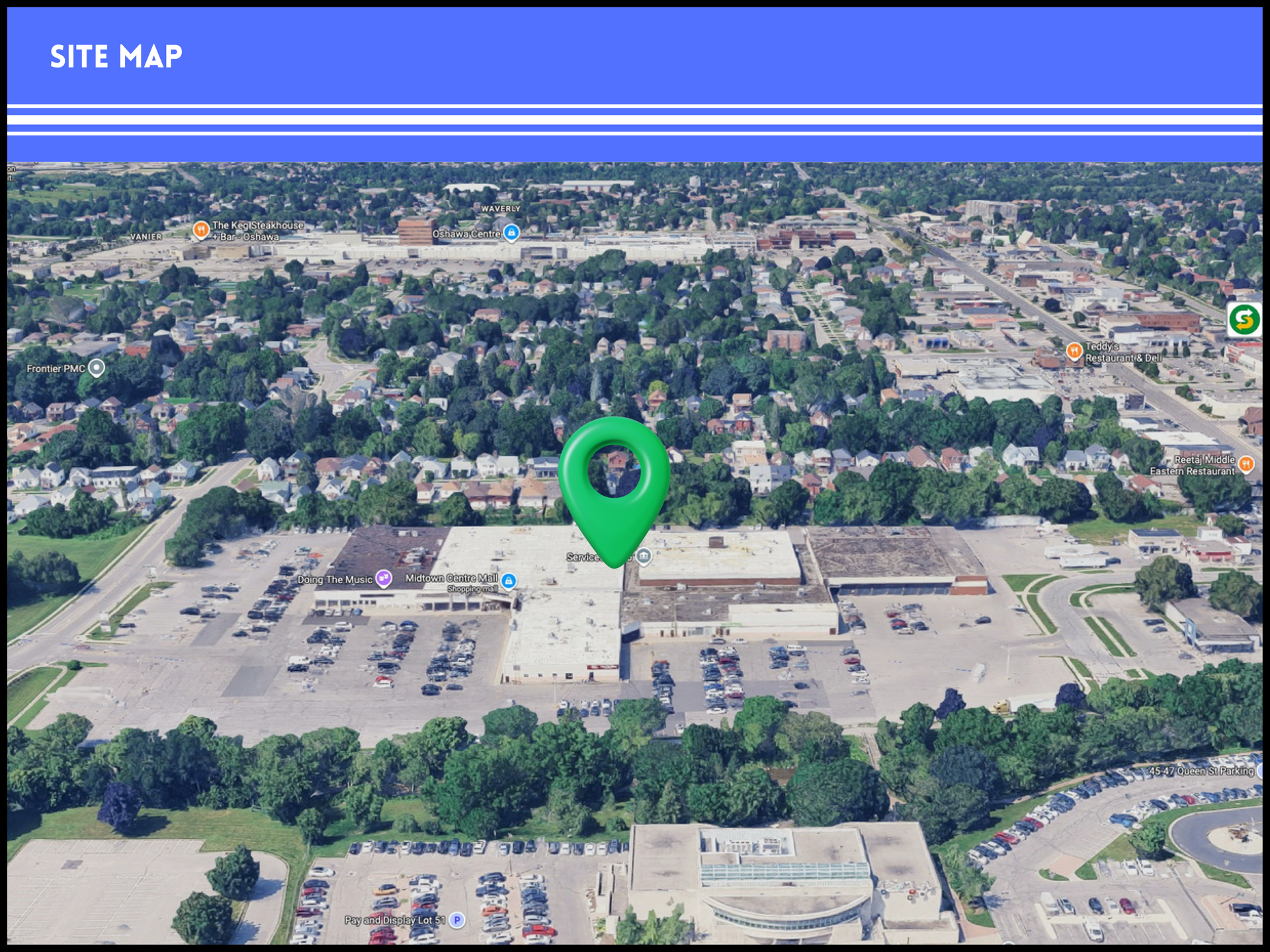 Aerial view of a shopping center site map with a large green map pin centered on the main building.