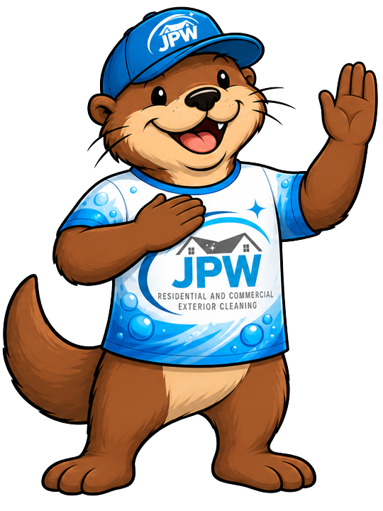 Cartoon otter mascot in blue JPW shirt and cap, waving and smiling with paw on chest