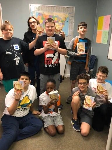 Students holding a book — Daytona Beach, FL — Monarch Academy