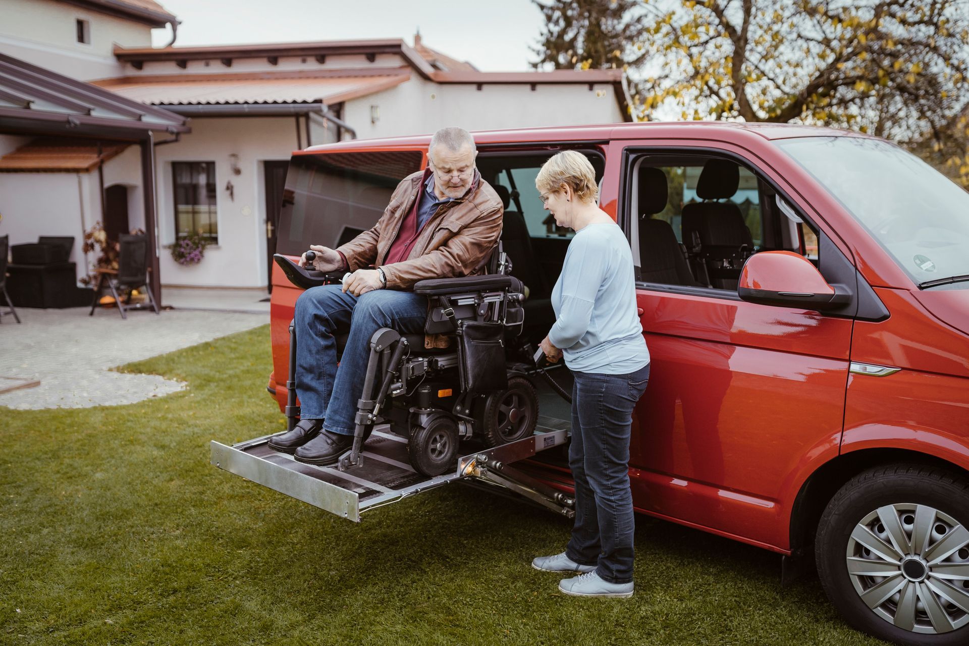 A woman is assisting an elderly man with transportation service in an accessible van.