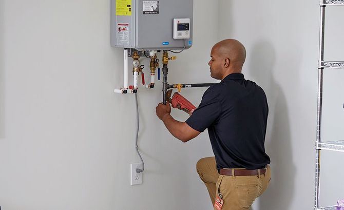 A technician in work gloves repairs a boiler, adjusting the internal pump and components.