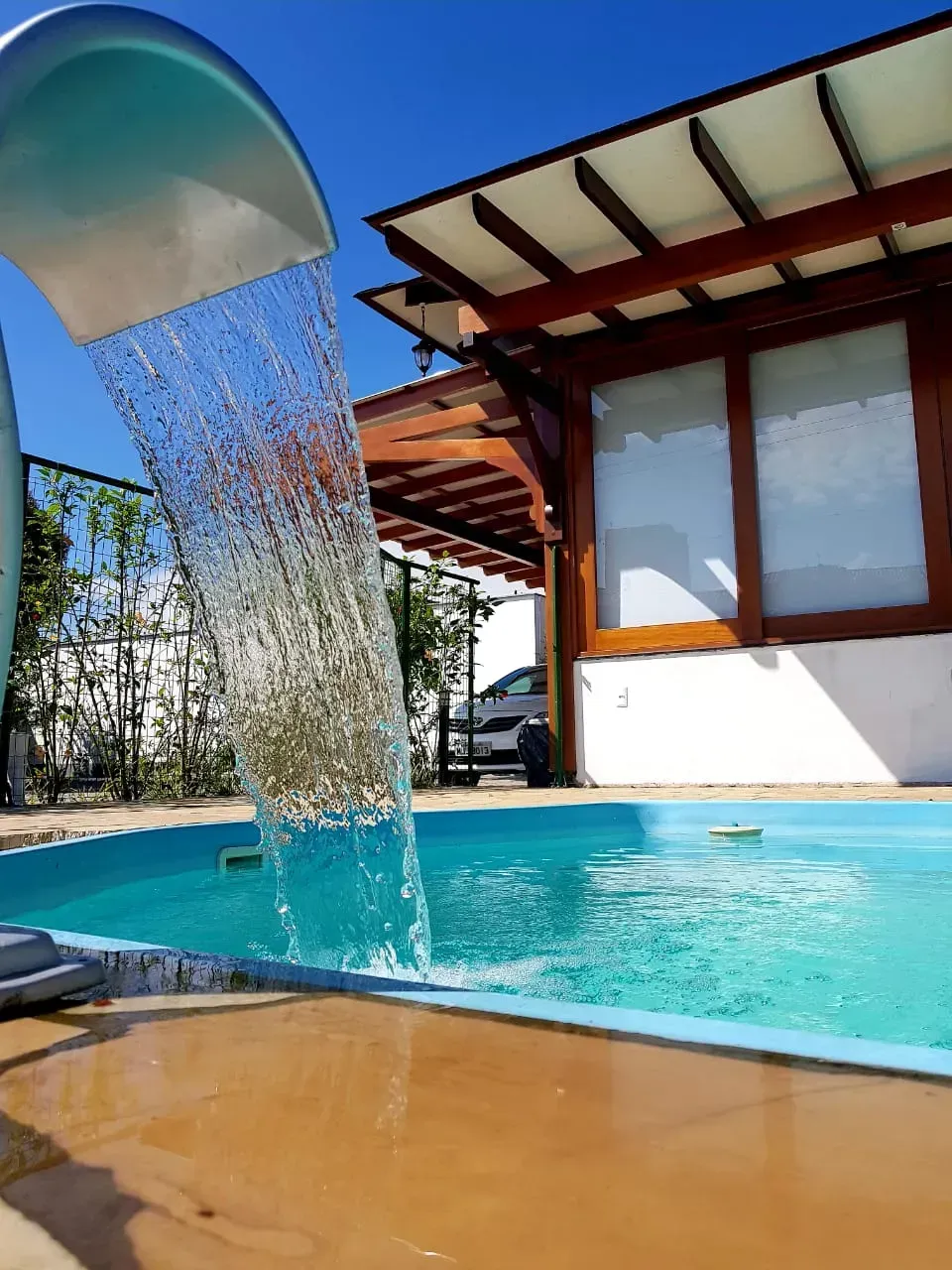 Uma cachoeira está despejando água em uma piscina-Pousada-Nascer do Sol
