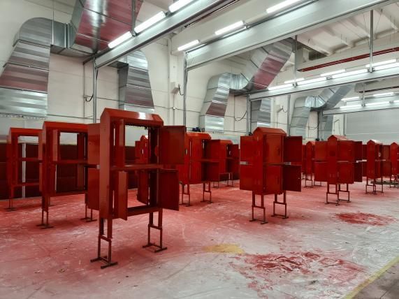 Strutture dipinte di rosso in un grande spazio industriale.