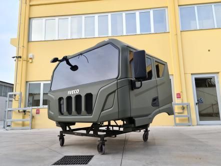 Cabina di un camion Iveco verde oliva su un supporto con ruote
